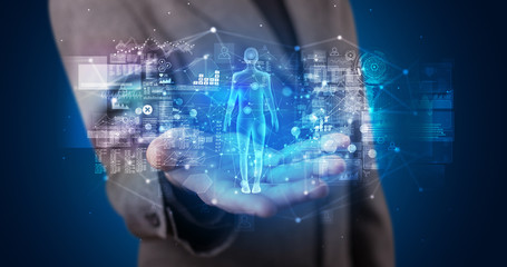 Young person holding hologram projection displaying health related graphs and symbols