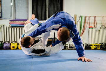 Brazilian Jiu Jitsu BJJ martial arts training sparring at the academy two fighters reverse de la...