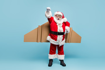 Full length body size view of his he nice fat cool glad cheerful cheery excited bearded Santa wearing plane wings fast shipping shop delivery service isolated over blue pastel color background