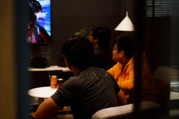 Asian men play games in a dark room