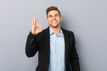 Young handsome caucasian man cheerful and confident showing ok gesture.