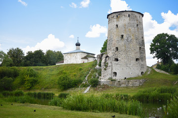Fototapeta na wymiar Fortress defensive tower next to the white church