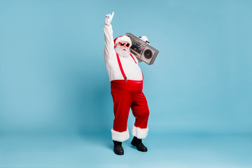 Full length body size view of his he nice cool stylish cheerful Santa big belly pants carrying vintage cassette player dancing isolated on bright vivid shine vibrant blue turquoise color background