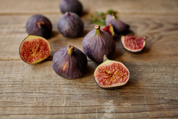 A few figs in a bowl on an old wooden background.