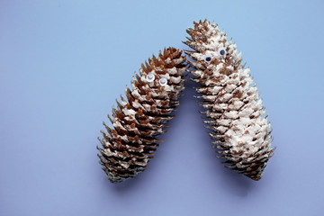 Two New Year's funny cones with plastic eyes on a purple background. New year, holiday, postcard, decoration. View from above