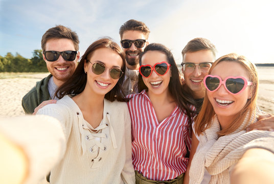 friendship, leisure and people concept - group of happy friends taking selfie on beach in summer