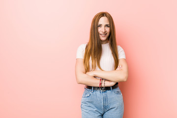 Obraz premium Young redhead ginger woman against a pink wall laughing and having fun.