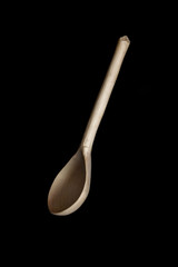 Wooden spoon on black background