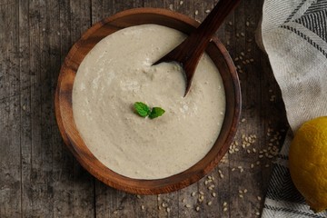 Homemade Tahini Sauce / Paste -Middle Eastern Dip in a wooden bowl, top view