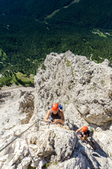 two women mountain climbers on an exposed Via Ferrata in the Dolomites of Italy