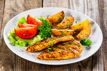 Grilled chicken fillet and vegetableson white plate