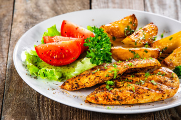 Grilled chicken fillet and vegetableson white plate