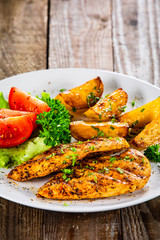 Grilled chicken fillet and vegetableson white plate
