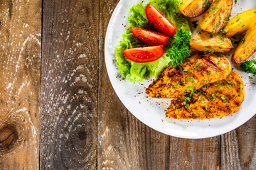 Grilled chicken fillet and vegetableson white plate