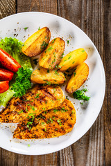 Grilled chicken fillet and vegetableson white plate