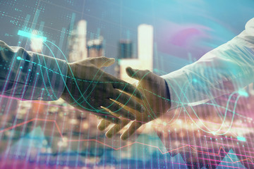 Double exposure of financial chart on cityscape background with two businessmen handshake. Concept...