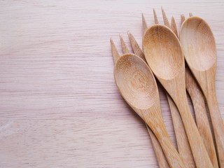 Three pairs of wooden spoon and fork set on a cutting board with copy space