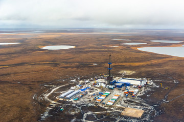 Drilling rig and equipment at an oil field in the northern tundra. Top view from a helicopter....