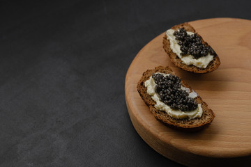 Sandwich with black caviar on black background