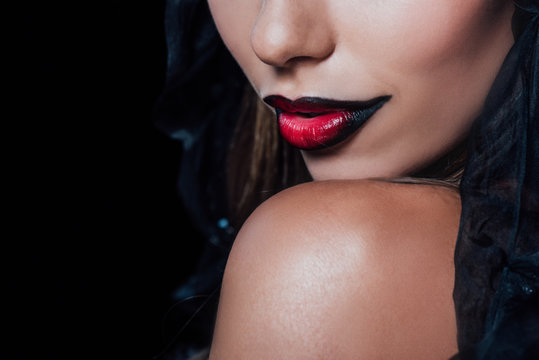 cropped view of dark black and red lips isolated on black