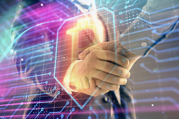 Multi exposure of bitcoin sign on abstract background with two men handshake. Concept of cryptocurrency