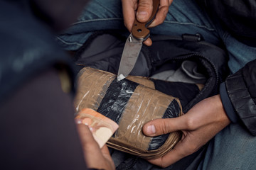 A person with money buys a dose of cocaine or heroin or other drug from a drug dealer