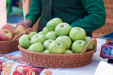 green ripe apples in a basket in a market