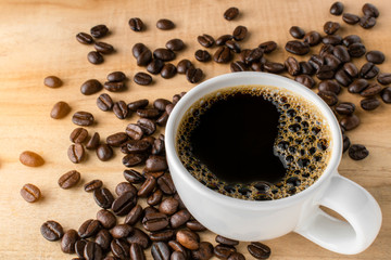 Coffee cup and coffee beans on wooden table