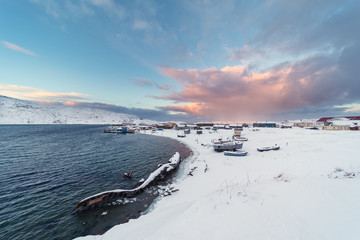 View of the old Russian fishing village of Teriberka with a shipwreck at the mouth of the namesake river on the Barents Sea, well above the Arctic circle in the Kola Peninsula near Murmansk