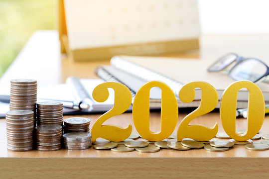 Word 2020 put on coins with coins stack on desk .Savings New year Concept.
