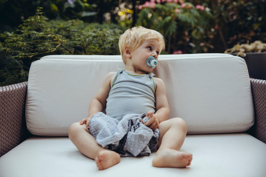 Kleinkind mit Schnuffeltuch und Nuckel in Loungechair