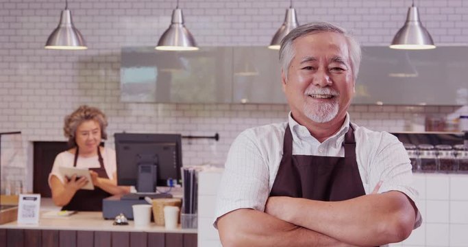 Senior barista posing with happy emotion to camera. Happy barista success to start up he business.