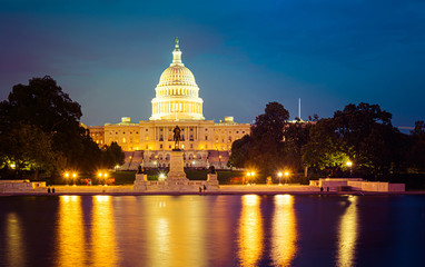 Panorama of the Capitol of the Unites States in evening light with the Capitol Reflecting Pool in the foreground.