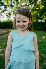 Portrait of a blond little girl at the park on a sunny day in summer