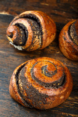 bun with poppy seeds on wooden background