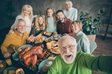 Photo of big family sit hugging feast dishes table around roasted turkey multi-generation relatives...