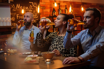Group of friends watching tv in a cafe behind bar counter