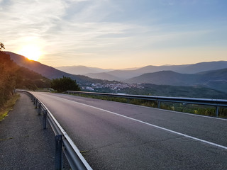 Asphalted road on a cliff with beautiful views to a small village and mountains
