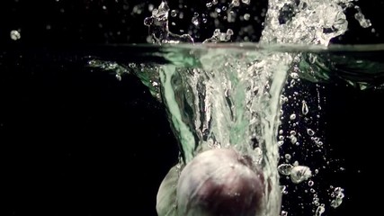 Figs splashing into water on black background closeup in super slow motion - Powered by Adobe
