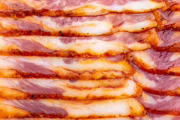 Close-up of appetizing slices of smoked bacon. With baking paper.
