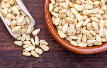 Peeled pine nuts. Aerial view (from above, top view). Foreground (Close-up). Wood background Rustic, natural and homemade appearance.