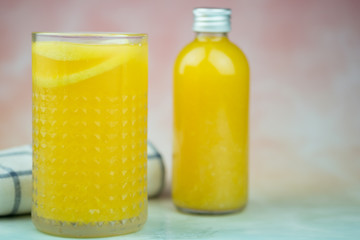 Bottle and glass of orange juice made of fresh oranges