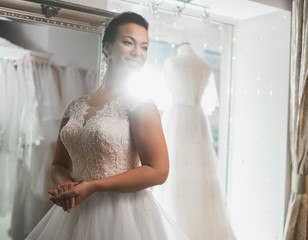 Beautifu bride choosing wedding dress in a wedding salon