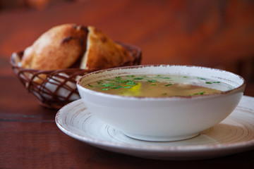table setting, chicken soup with bread on a wooden background