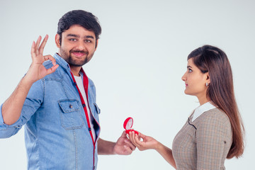 bold indian man asking her girlfriend to get wedding studio white background