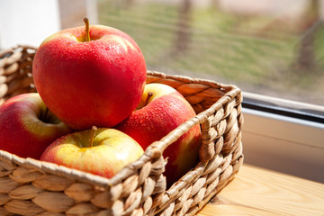 apples in a basket near the window
