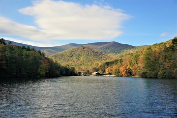 Fototapeta premium Fantastic view of colorful mountain with reflection in the lake at Vogel State park with blue sky white clouds on the background, Autumn in GA USA.