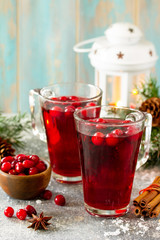 Christmas drinks. Hot winter drink with cranberries and cinnamon on a light stone table. Free space for your text.