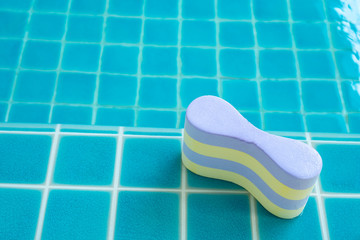 yellow and purple pool bouy  placed on the edge of the pool