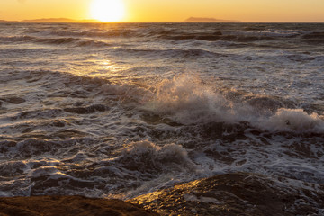 Beauty of the sea -  splashing waves lighted by the sunset.